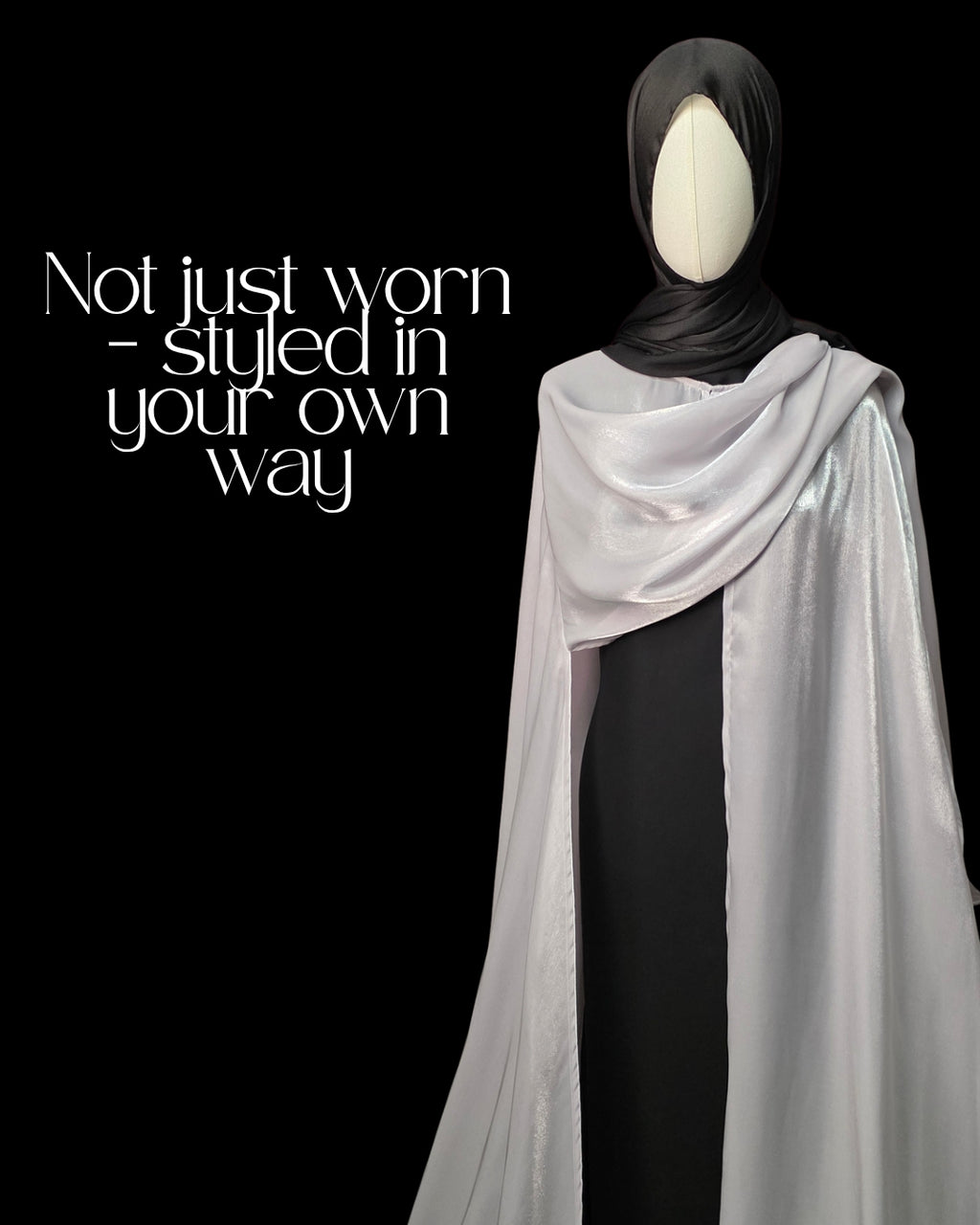 Mannequin wearing a black hijab and white scarf with text 'Not just worn - styled in your own way' on a black background