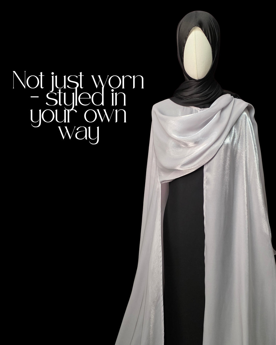 Mannequin wearing a black hijab and white scarf with text 'Not just worn - styled in your own way' on a black background